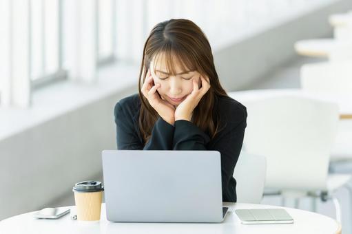 パソコンを使いながら考える女性 女性,パソコン,考えるの写真素材