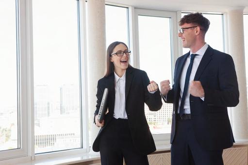 小さくガッツポーズをする笑顔の外国人男女 男女,ガッツポーズ,笑顔の写真素材