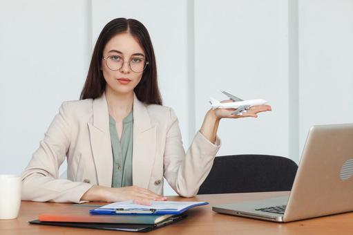 飛行機の模型を手に持つ女性スタッフ 事務職,接客業,アドバイザーの写真素材