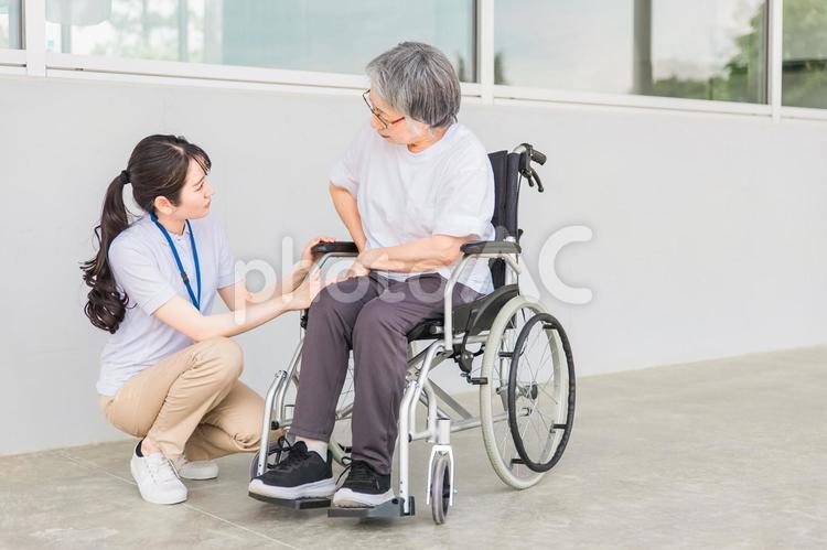 車椅子に乗る高齢者と介護士（股関節） 股関節,高齢者,車椅子の写真素材