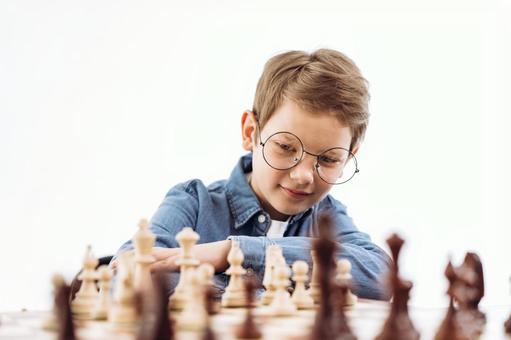 チェスを見ている楽しそうな男の子(白背景) チェスを見ている楽しそうな男の子(白背景) チェス,子ども,男の子の写真素材