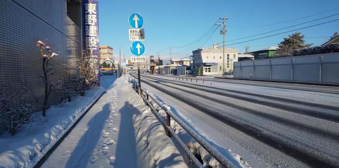 早朝の積雪のある歩道の写真