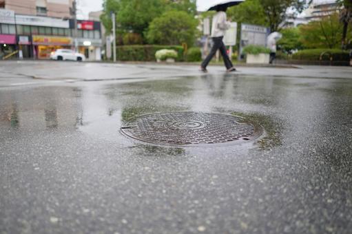 マンホールにたまった雨水 雨,水たまり,アスファルトの写真素材