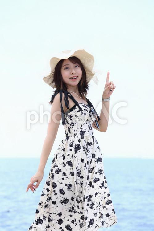 海辺で人差し指を立てる女性 女性,海辺,人差し指の写真素材