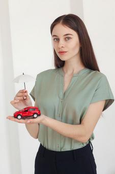 車の模型を持つ女性 保険業,事務職,接客業の写真素材
