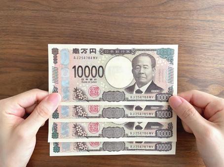 机上で4万円を持つ女性の手元 机上で4万円を持つ女性の手元 お金,給付金,持つの写真素材