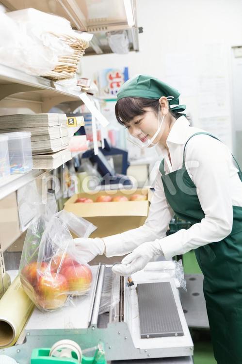 スーパーの裏方で働く人々　袋詰め スーパー,スーパーマーケット,バックヤードの写真素材