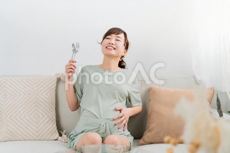スプーンとフォークを持つ日本人の妊婦 妊婦,肥満,大食いの写真素材