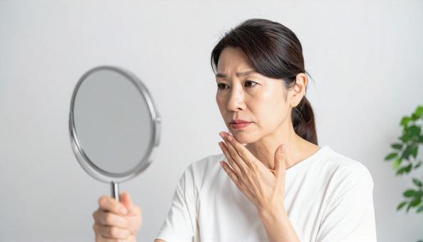 日本人ミドル女性スキンケア・悩むイメージの写真