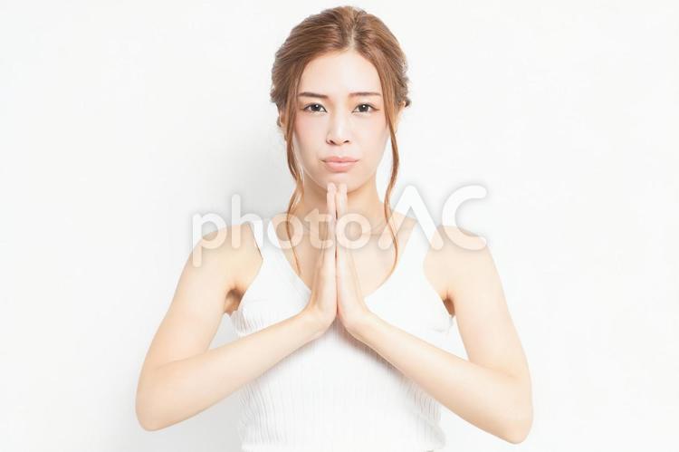 お願いのジェスチャーをする若い女性 女性,お願い,ポーズの写真素材