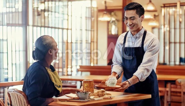 レストランでサービスをする男性スタッフ 男性,カフェ店員,ウエイトレスの写真素材