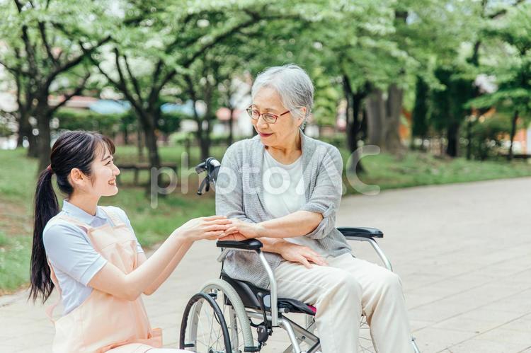車椅子に乗った高齢者女性と女性スタッフ 車椅子に乗った高齢者女性と女性スタッフ 介護士,介護福祉士,看護師の写真素材