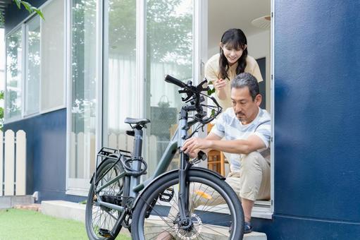 電動自転車をメンテナンスをするミドル男性 電動自転車,男性,夫婦の写真素材
