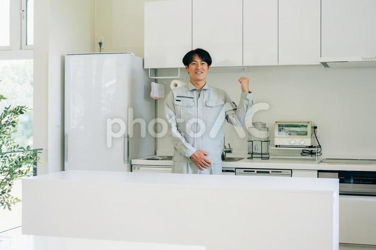 キッチンと作業着姿の男性　 工務店,作業服,設備の写真素材