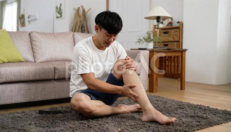 急に足が攣って痛がっている男性 こむらがえり,足が攣る,痛いの写真素材
