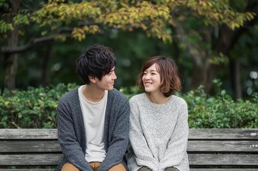 公園のベンチで語り合う二人 公園のベンチで語り合う二人の写真