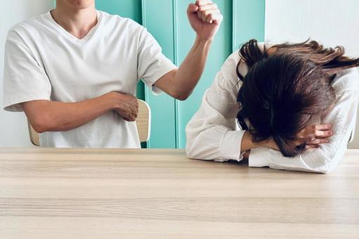 女性にこぶしを振りあげる男性 女性にこぶしを振りあげる男性の写真