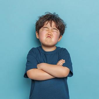 腕組みで自分の気持ちを示す幼い男の子 腕組みで自分の気持ちを示す幼い男の子の写真