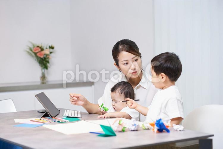 リモート中の母親の横で遊ぶ子供 女性,リモートワーク,子育ての写真素材