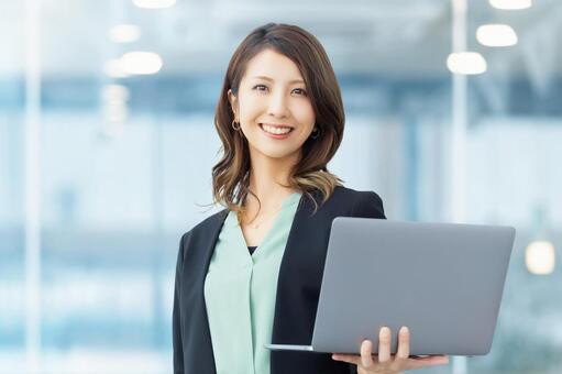 パソコンを持つ女性・ビジネスウーマン 女性,パソコン,笑顔の写真素材