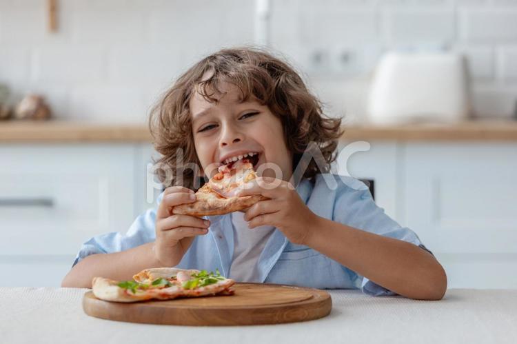 ピザを食べて微笑む男の子２ 男の子,ピザ,持つの写真素材