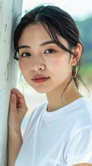 白いTシャツの女性が壁際でポーズをとる 白いTシャツの女性が壁際でポーズをとるの写真