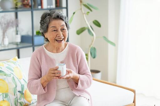 リビングでお茶を飲むシニアの女性 シニア,女性,笑顔の写真素材