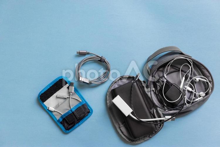 ポーチに絡まって入っているコードやイヤフォン ポーチ,アダプター,黒の写真素材