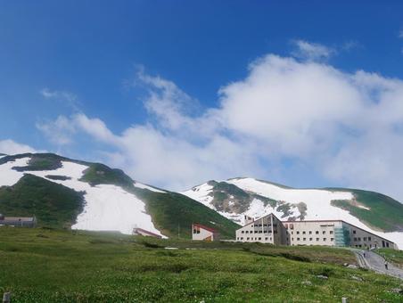 残雪の山と山小屋の写真