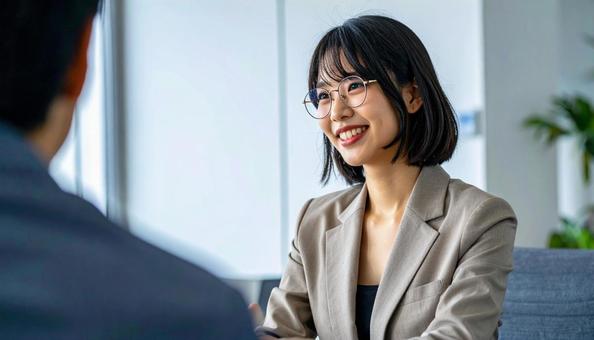 笑顔で話すスーツ姿の女性の写真