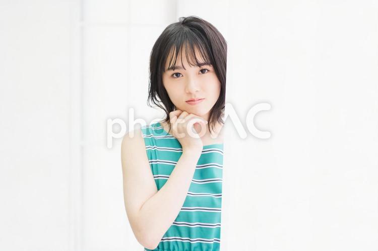 窓際に立ってこちらを見つめている若い女性 窓際,立つ,若いの写真素材