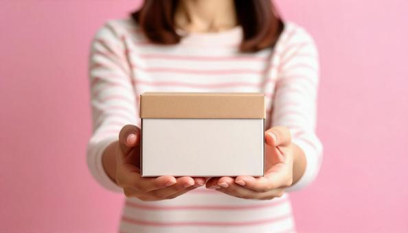 小さな段ボールを抱える日本人女性の手もと 小さな段ボールを抱える日本人女性の手もとの写真