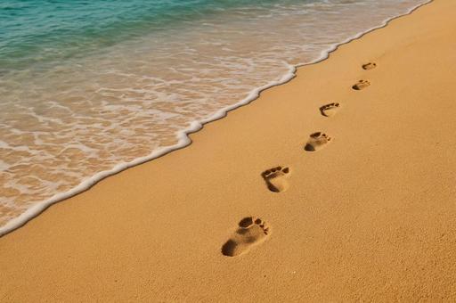 砂浜に続く足跡と波打ち際・夏のビーチ・旅 砂浜に続く足跡と波打ち際・夏のビーチ・旅の写真