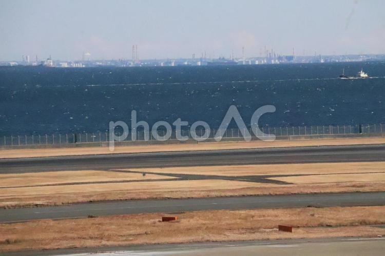 滑走路と青い海と対岸の街並みの見える風景 滑走路,青い,海の写真素材