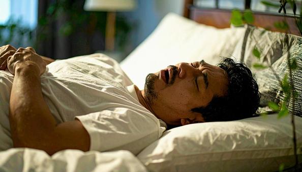 大きないびきをかいて眠る日本人男性 大きないびきをかいて眠る日本人男性の写真