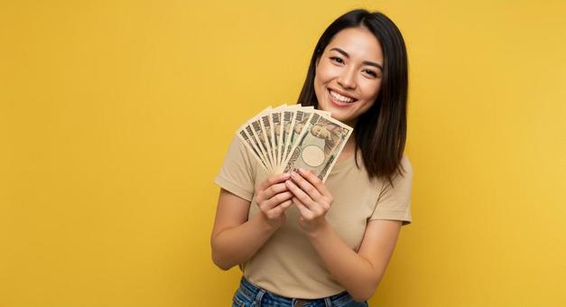 大金を手にして喜ぶ女性 大金を手にして喜ぶ女性の写真