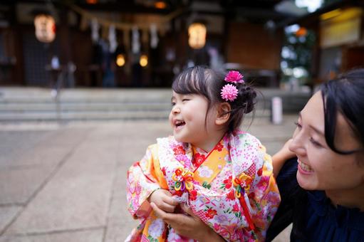 花飾りをつけた女の子を見つめる母 花飾りをつけた女の子を見つめる母 七五三,お参り,七五三参りの写真素材
