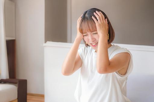 家で頭を抱える私服女性 女性,若者,困るの写真素材