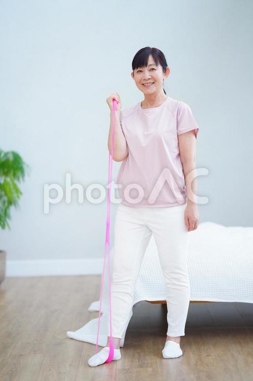 チューブを使って運動する笑顔の中年女性 主婦,シニア,立ち姿の写真素材