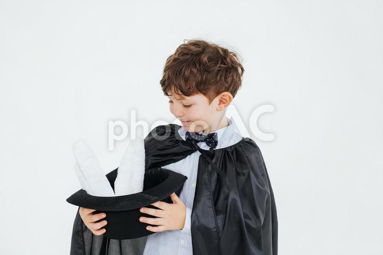 帽子から出ている白い耳を見る男の子 男の子,帽子,持つの写真素材