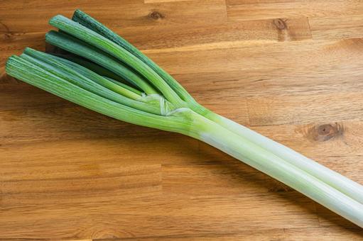 木目テーブルに置かれた白ネギ 木目テーブルに置かれた白ネギ 白ネギ,野菜,長ネギの写真素材