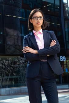 オフィスビルの外で腕組みをして立っているビジネスウーマン ビジネスウーマン,ビジネス,女性の写真素材