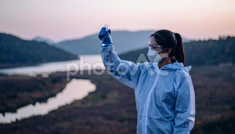 自然を背景に実験をする女性の研究者 バイオテクノロジー,研究開発,臨床試験の写真素材