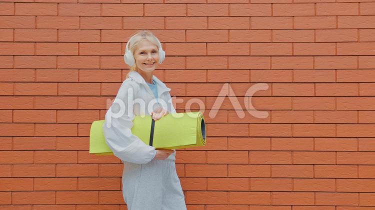 ヨガマットを持って笑顔の女性 女性,人物,元気の写真素材