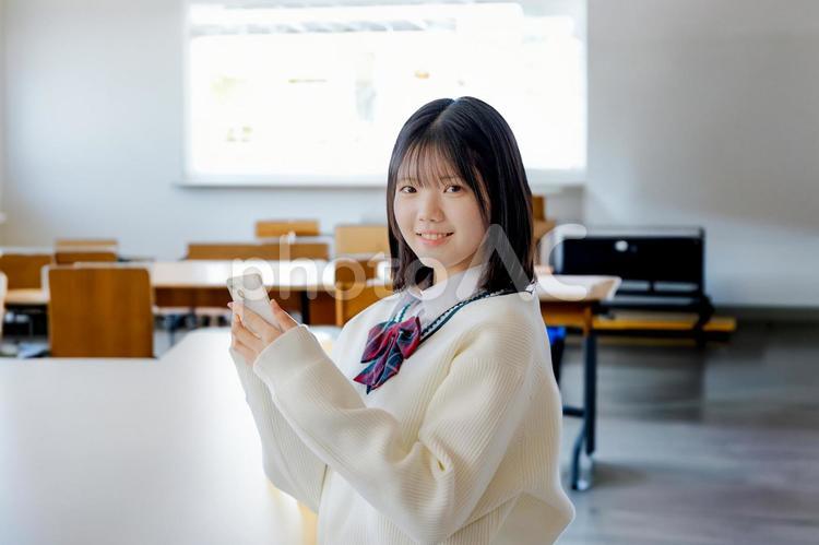 教室と女子生徒とスマホ 女子学生,女子生徒,中学生の写真素材
