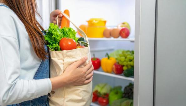 エコバッグから野菜を取り出し冷蔵庫へ エコバッグから野菜を取り出し冷蔵庫への写真