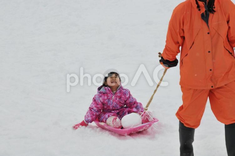 ソリ遊びをする親子（幼稚園児）01 ソリ遊び,雪遊び,冬の写真素材