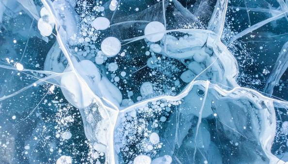 冬の湖面に広がる氷のバブルと亀裂模様 冬の湖面に広がる氷のバブルと亀裂模様の写真