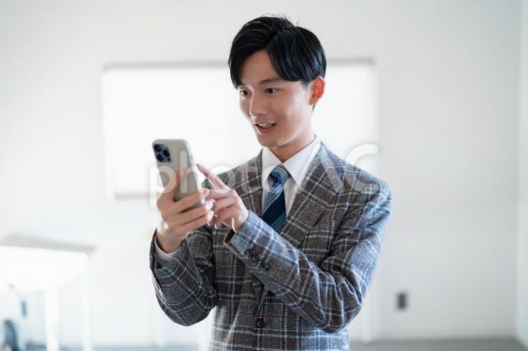 携帯を持つ男性 営業,男性,ビジネスマンの写真素材
