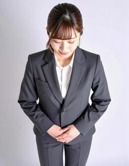 お辞儀するスーツ女性のビジネスマナーの写真